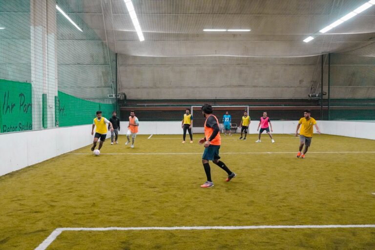 A lively indoor soccer game with diverse players actively engaging in the sport.