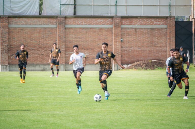 Energetic soccer match in Texcoco, Mexico with players in vibrant sportswear.