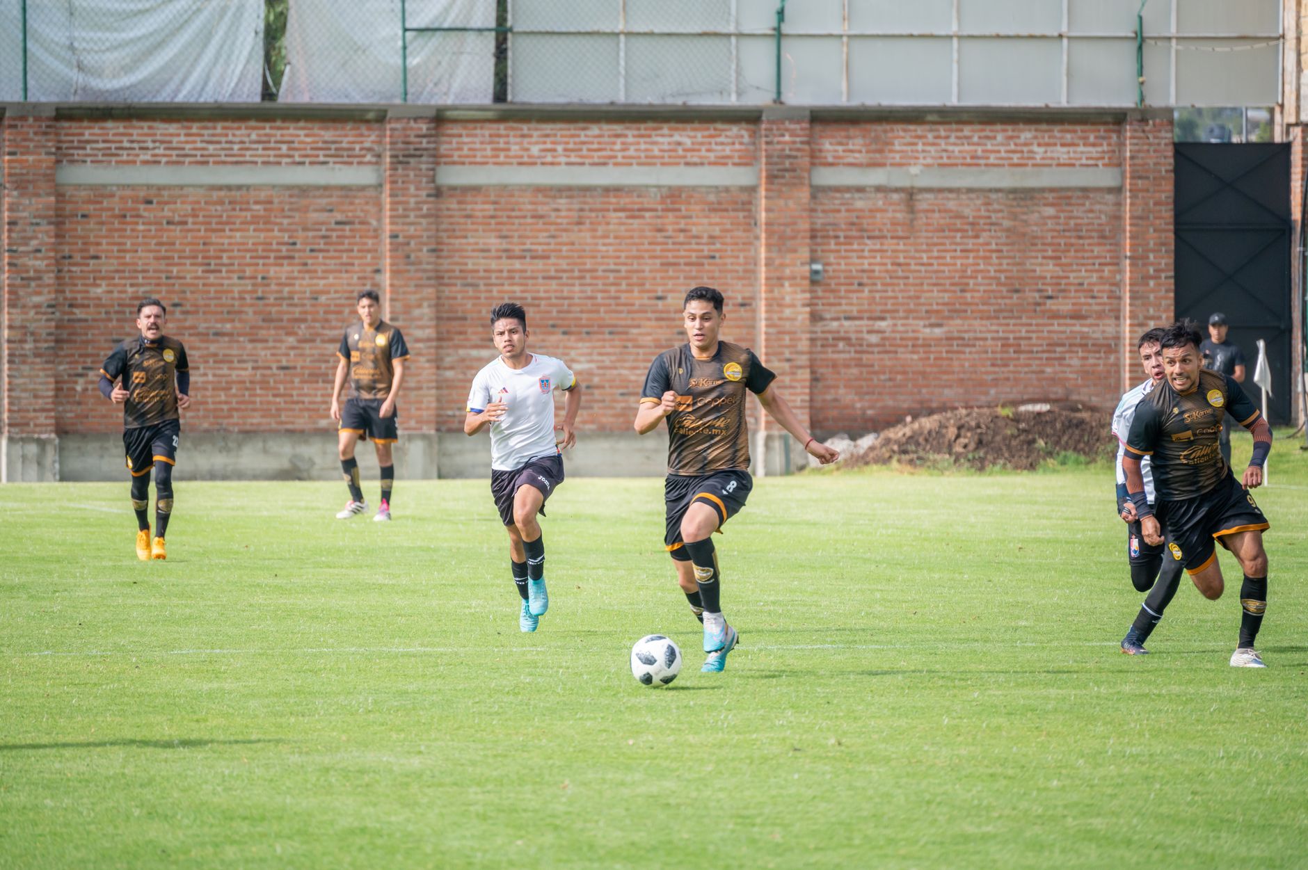 Energetic soccer match in Texcoco, Mexico with players in vibrant sportswear.