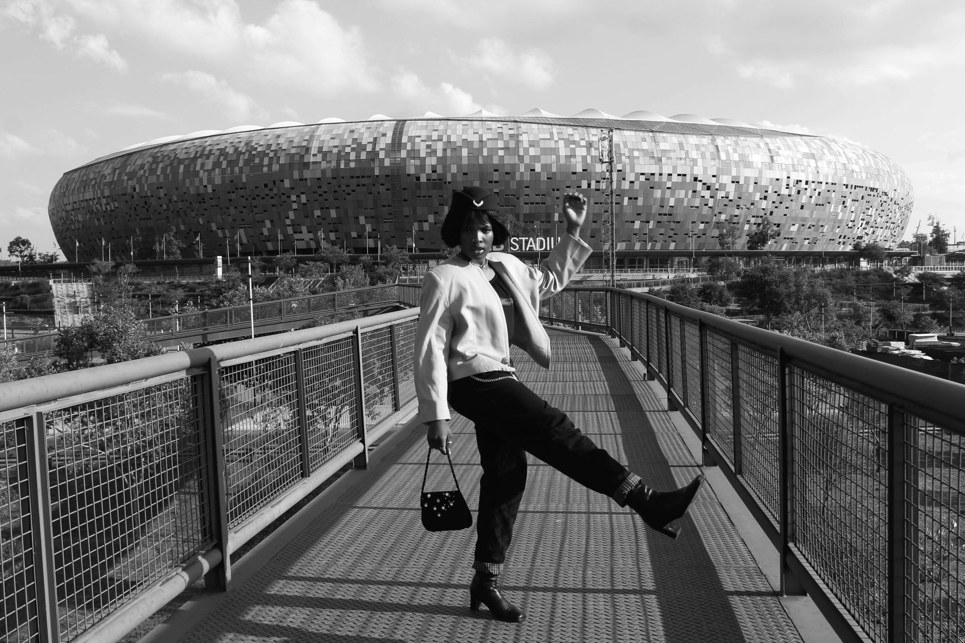 Fashionable individual posing on the bridge near FNB Stadium in Johannesburg, South Africa.