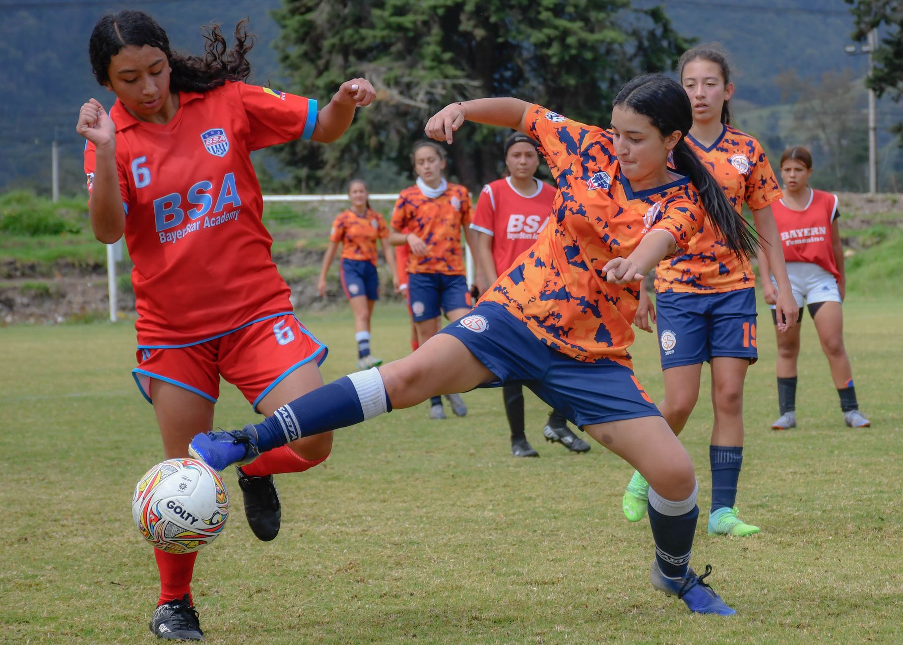Energetic girls' soccer game showcasing skill and teamwork on a vibrant day.
