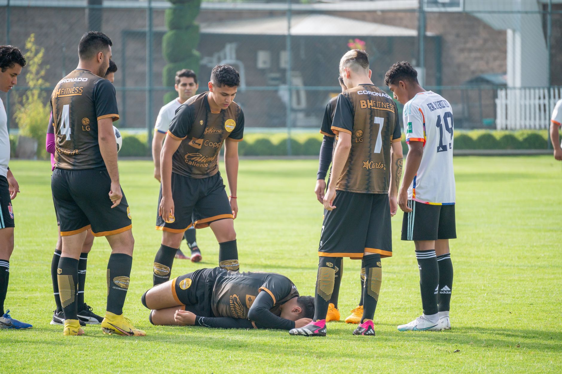 Soccer players gather around injured teammate during a match in Texcoco, Mexico.