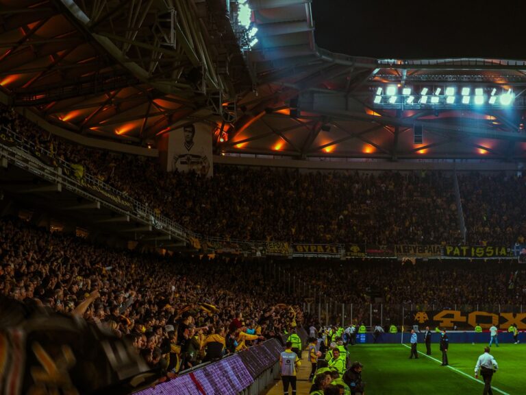 Exciting night soccer game with packed cheering fans and vibrant stadium lights.