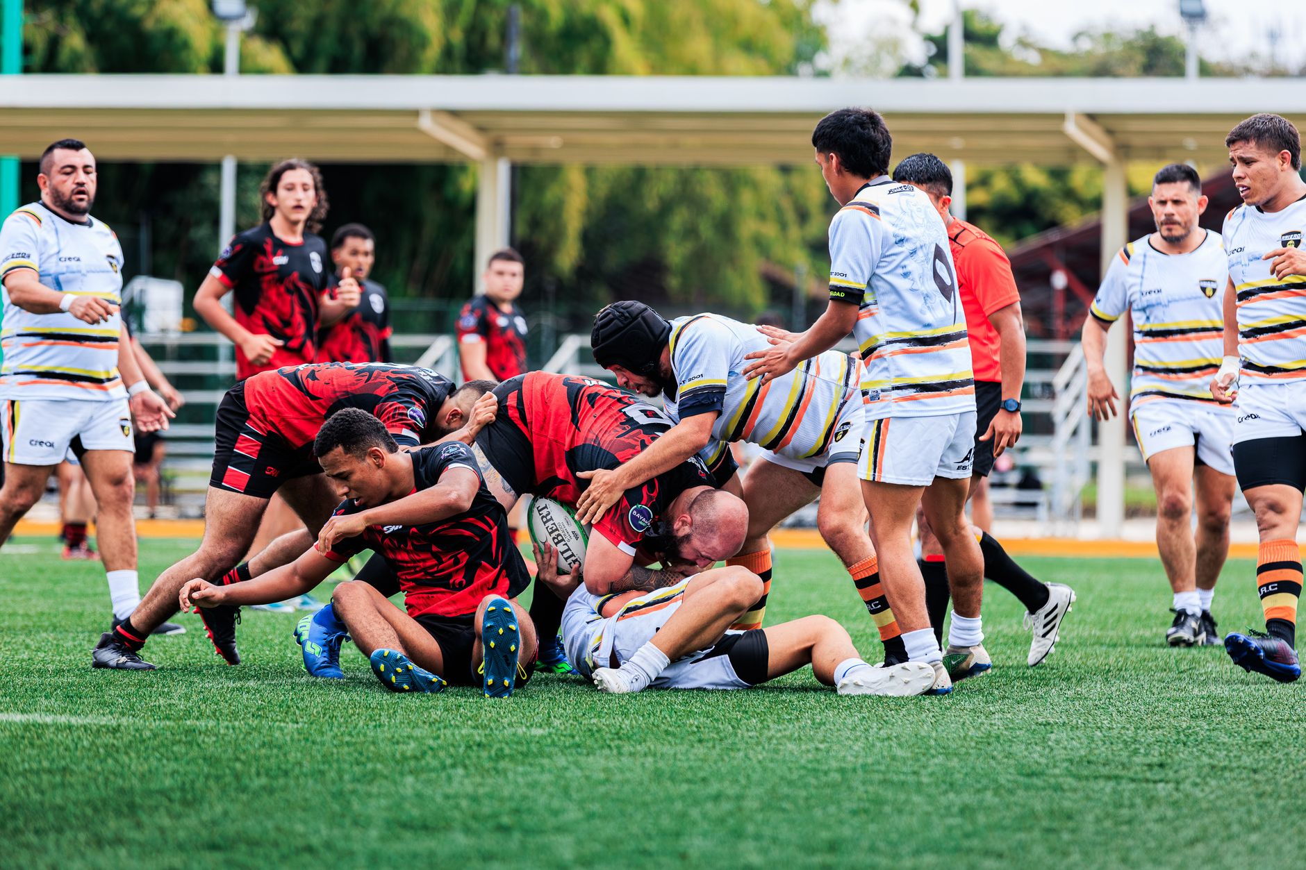 Action-packed rugby match featuring diverse players in vibrant jerseys on a sports field.