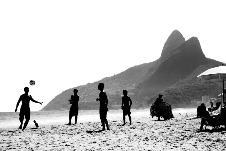 Black and white image of people playing soccer on Ipanema Beach, Rio de Janeiro.