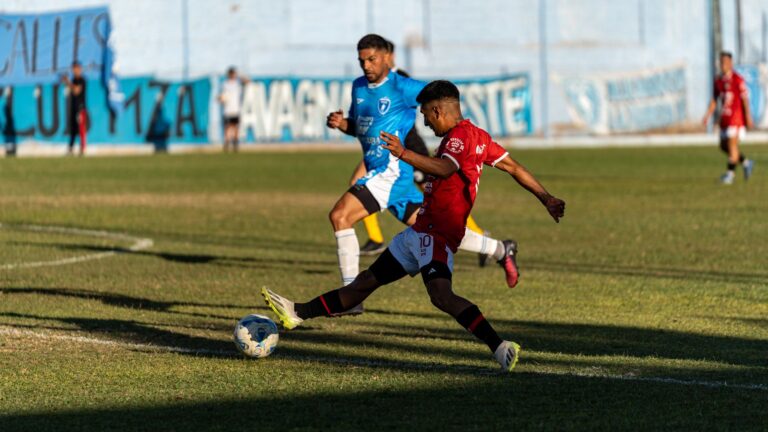 Dynamic soccer match with two players in action on a sunlit field.