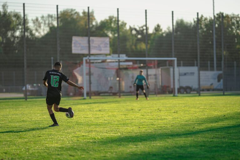 Captured moment of a soccer player taking a shot on goal during an outdoor match.