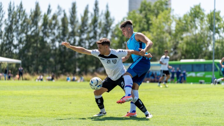 Two soccer players compete fiercely for the ball during an outdoor match.