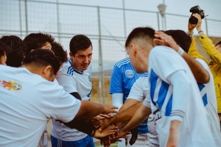 A soccer team gathers in a huddle for motivation before a match, fostering teamwork and unity.
