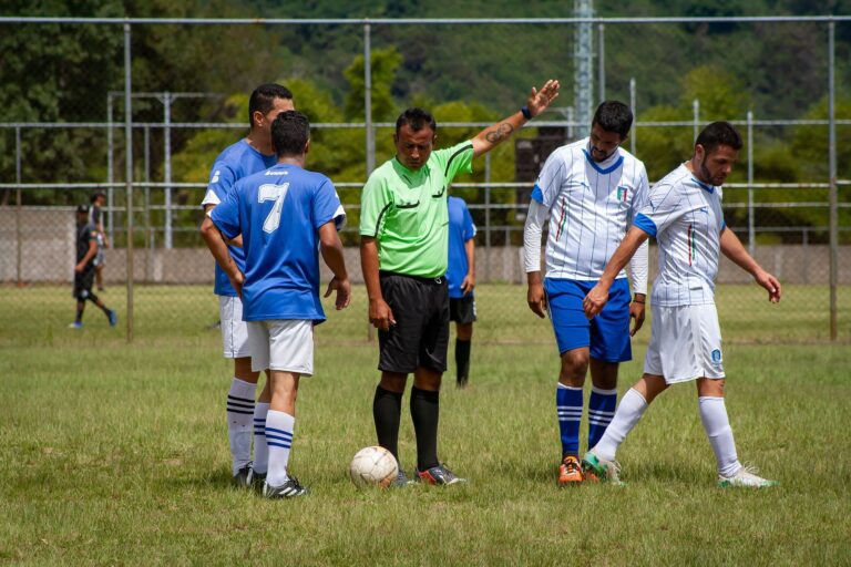 Soccer players and referee on a green field in Venezuela, mid-game action.
