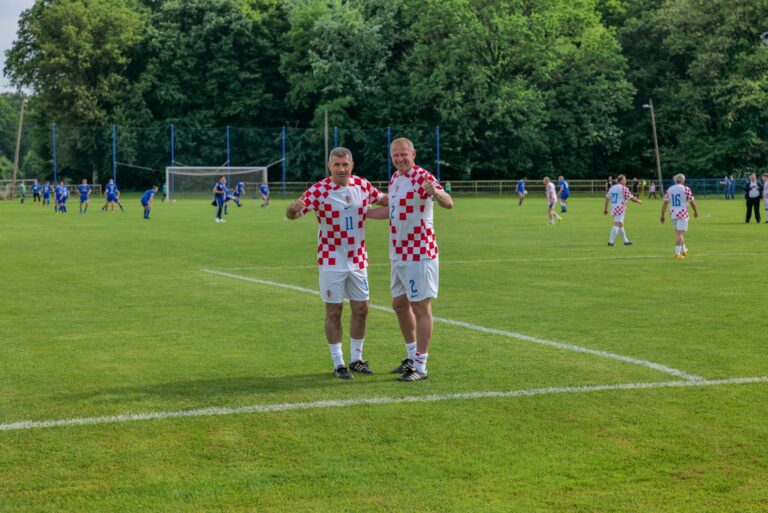 Soccer players pose before a match in a green field in Croatia.