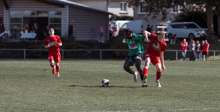 Players in action during an outdoor soccer match on a sunny day in France.