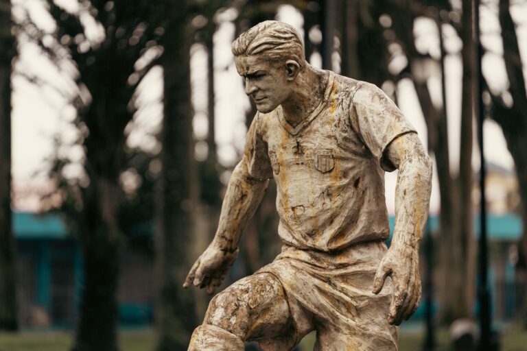 A rustic statue of a soccer player captured in a park in Alajuela, Costa Rica.