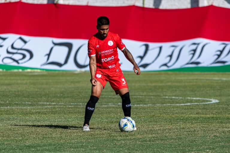 Soccer player in action on the field, preparing to make a play during a sunny day match.