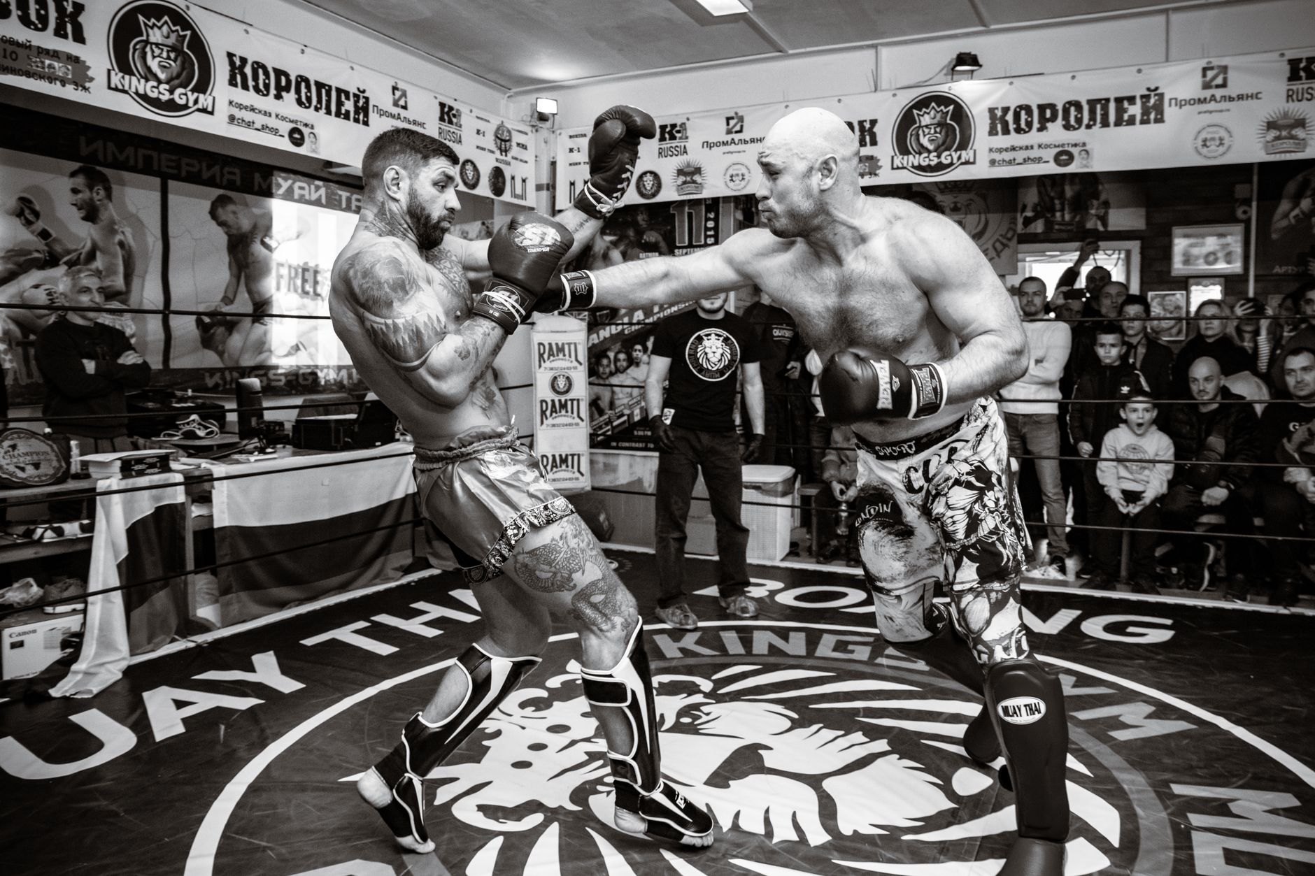 A dynamic black and white shot of a boxing fight in the ring capturing the energy and athleticism.