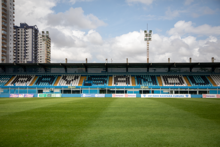 Empty Estádio Banpará Curuzu in Belém, Brazil with green grass and clear sky.