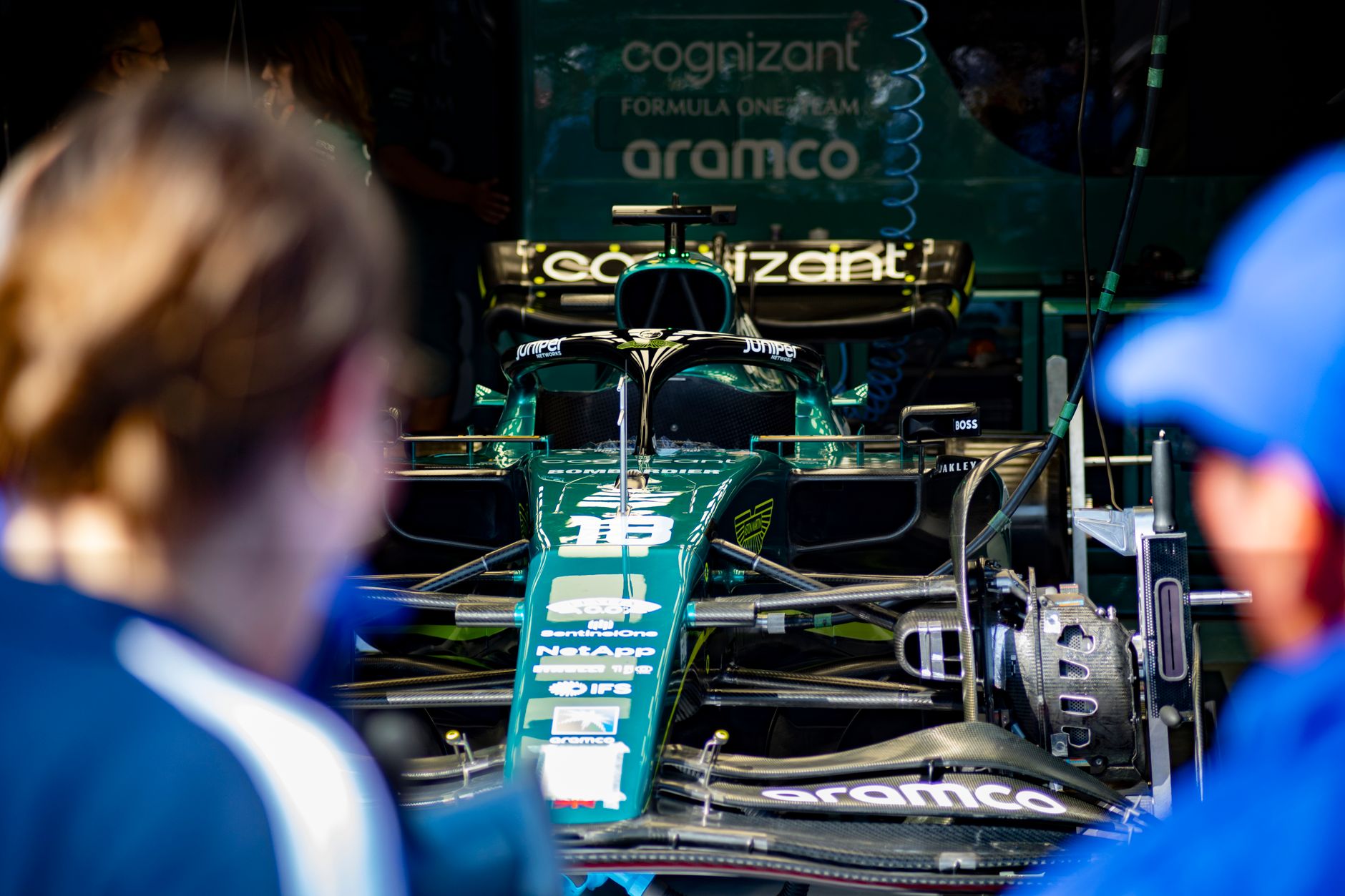 Aston Martin Formula 1 race car being prepared in the team garage before competition.
