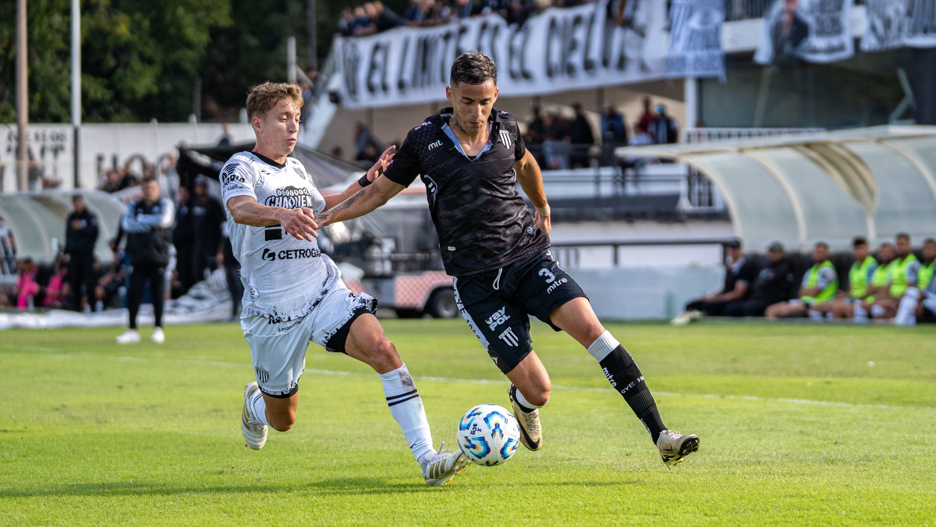 Two soccer players in action during a competitive outdoor match.