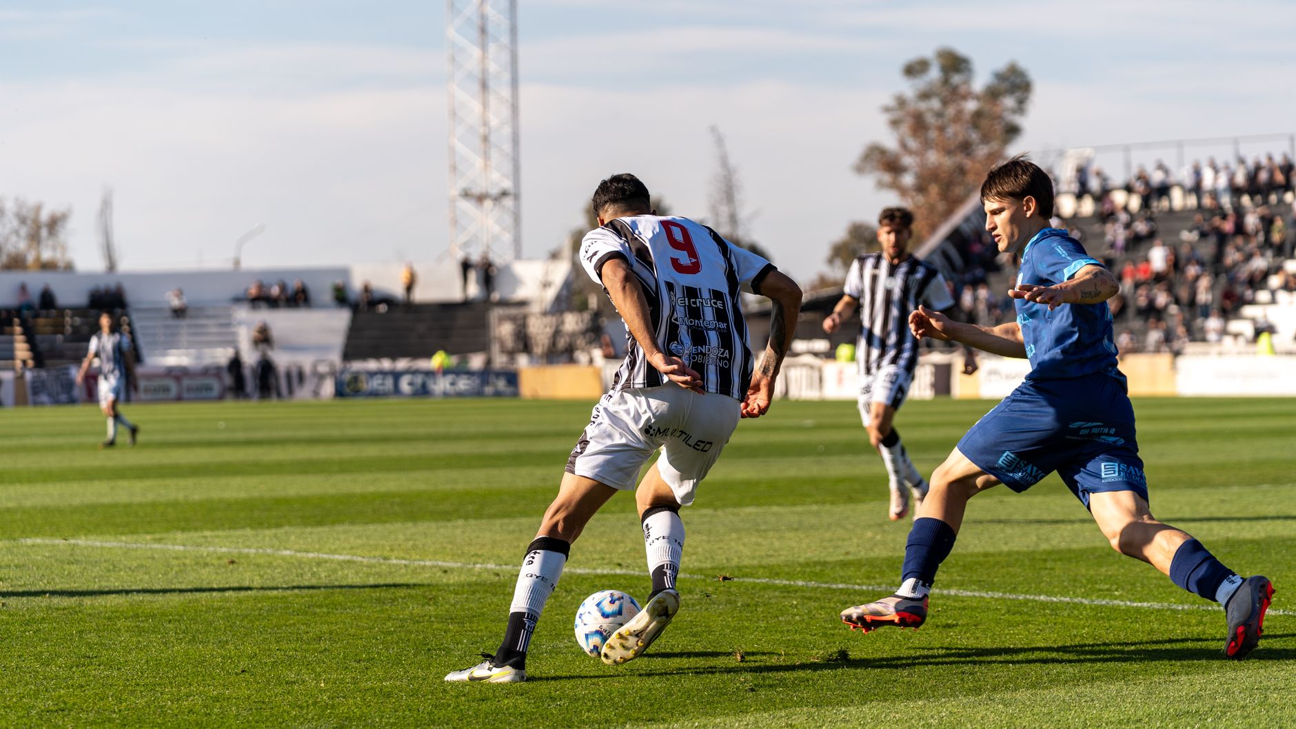 Soccer players in a dynamic match showcasing skill and teamwork during a sunny day game.