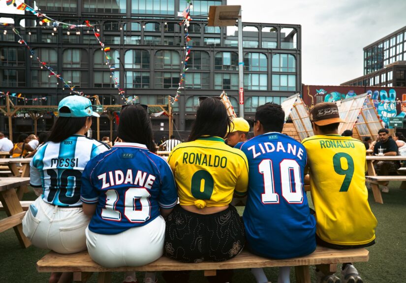 Group of people wearing soccer jerseys at an outdoor venue in Chicago, enjoying a lively atmosphere.