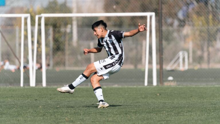 A soccer player skillfully kicks the ball during a game on an outdoor field.