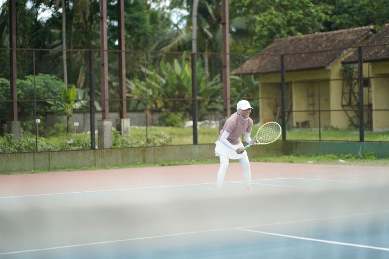 A focused tennis player poised on an outdoor court, capturing the dynamic nature of the sport.