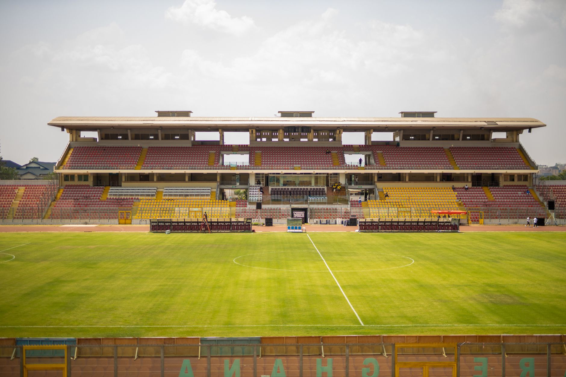 A wide view of the empty Baba Yara Sports Stadium in Kumasi, showcasing its structure and green field.