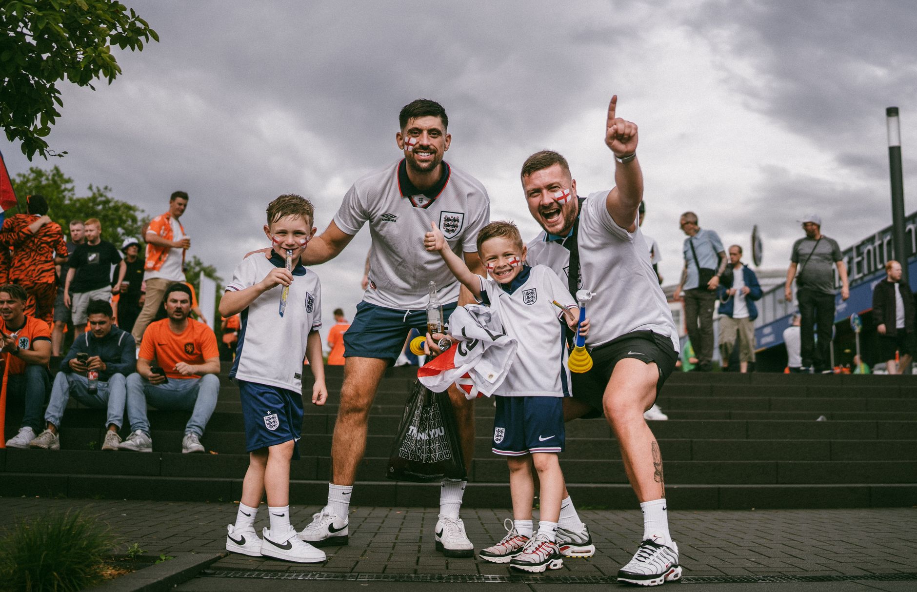 Group of enthusiastic soccer fans celebrating victory outside the stadium on game day.