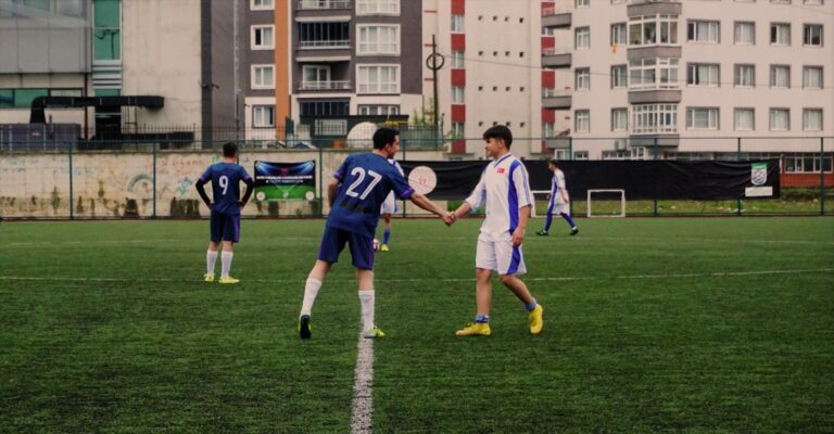 Soccer players shaking hands on an urban pitch in Tirebolu, Türkiye.