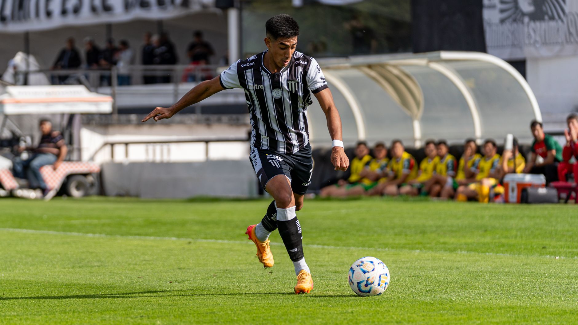 An athletic soccer player in motion during a game on a green field.