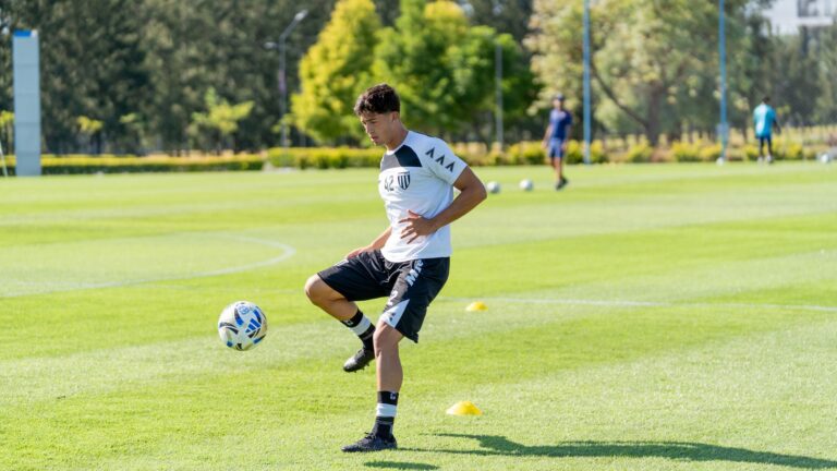 A young soccer player practices juggling on a sunny outdoor field, emphasizing athletic dedication.