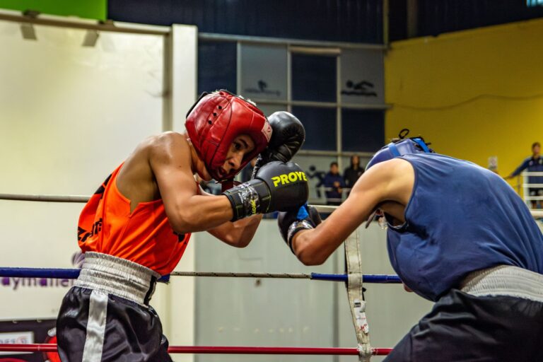 Two athletes engage in a dynamic boxing match, showcasing skill and strength in the ring.