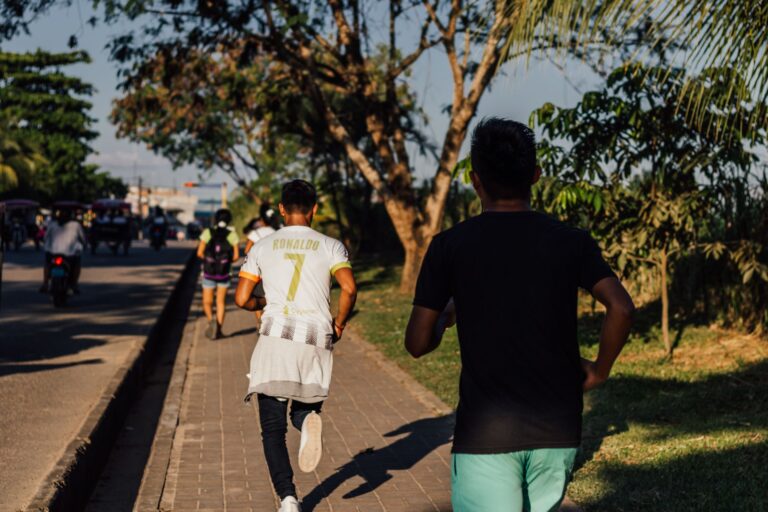 Two men jogging on a sidewalk in Yurimaguas, capturing urban fitness.