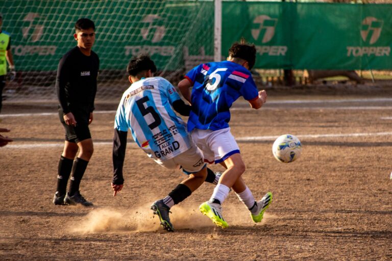 Intense soccer match action with two players competing for the ball on an outdoor field.