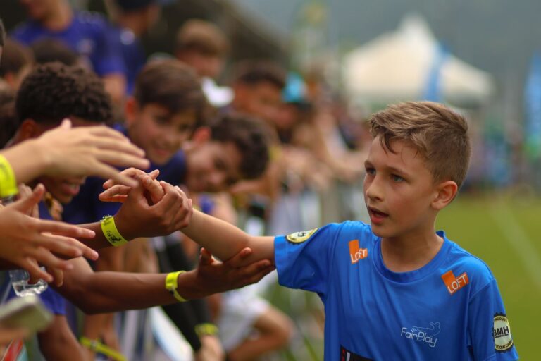 Young athlete high-fives the crowd at an outdoor sports event in Florianópolis, Brazil.