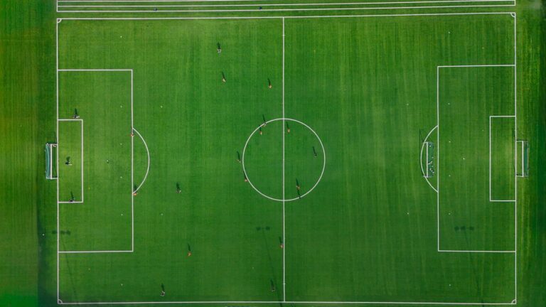 Aerial shot of a soccer field with players in Jönköping, Sweden, showcasing vibrant green grass.