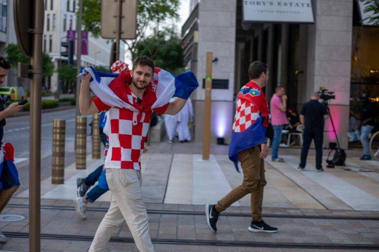 Croatian soccer fans celebrating with flags in the streets of Doha, Qatar during the World Cup.
