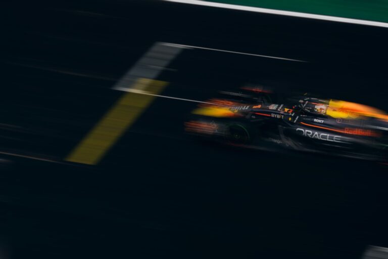 Blurred image of a Formula One car racing down the track, showcasing speed and motion.
