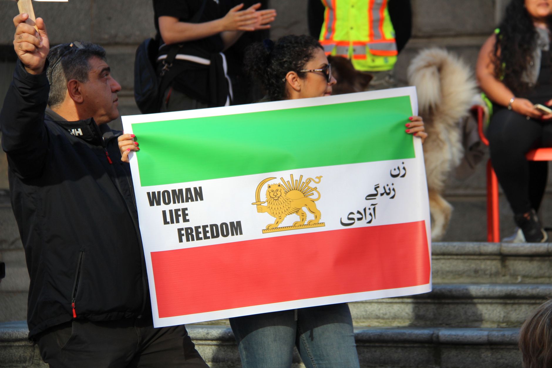 People holding signs for the Woman Life Freedom protest in Vancouver, Canada.