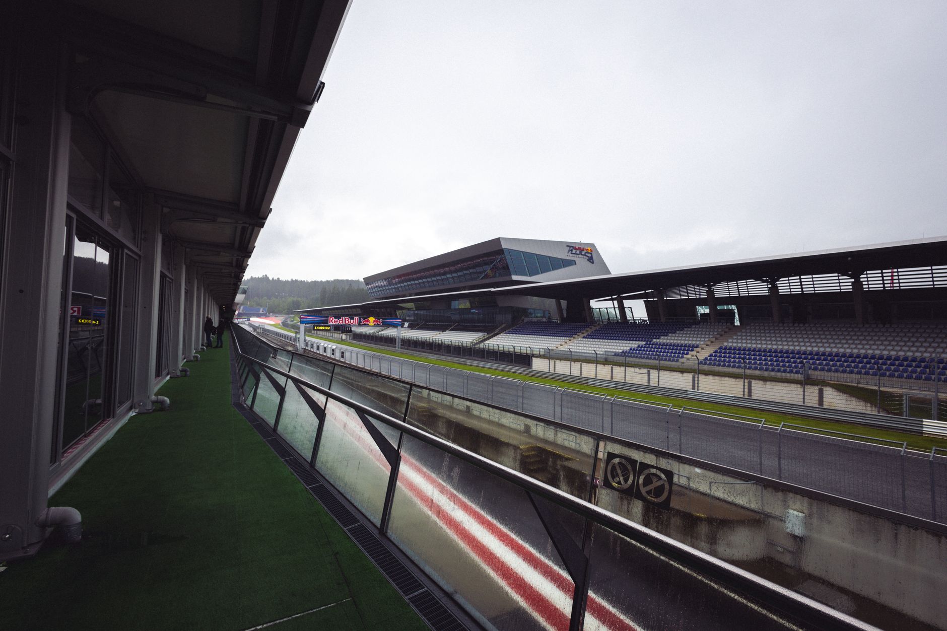 Empty Red Bull Ring racetrack in Spielberg, Austria with grandstands on a cloudy day.