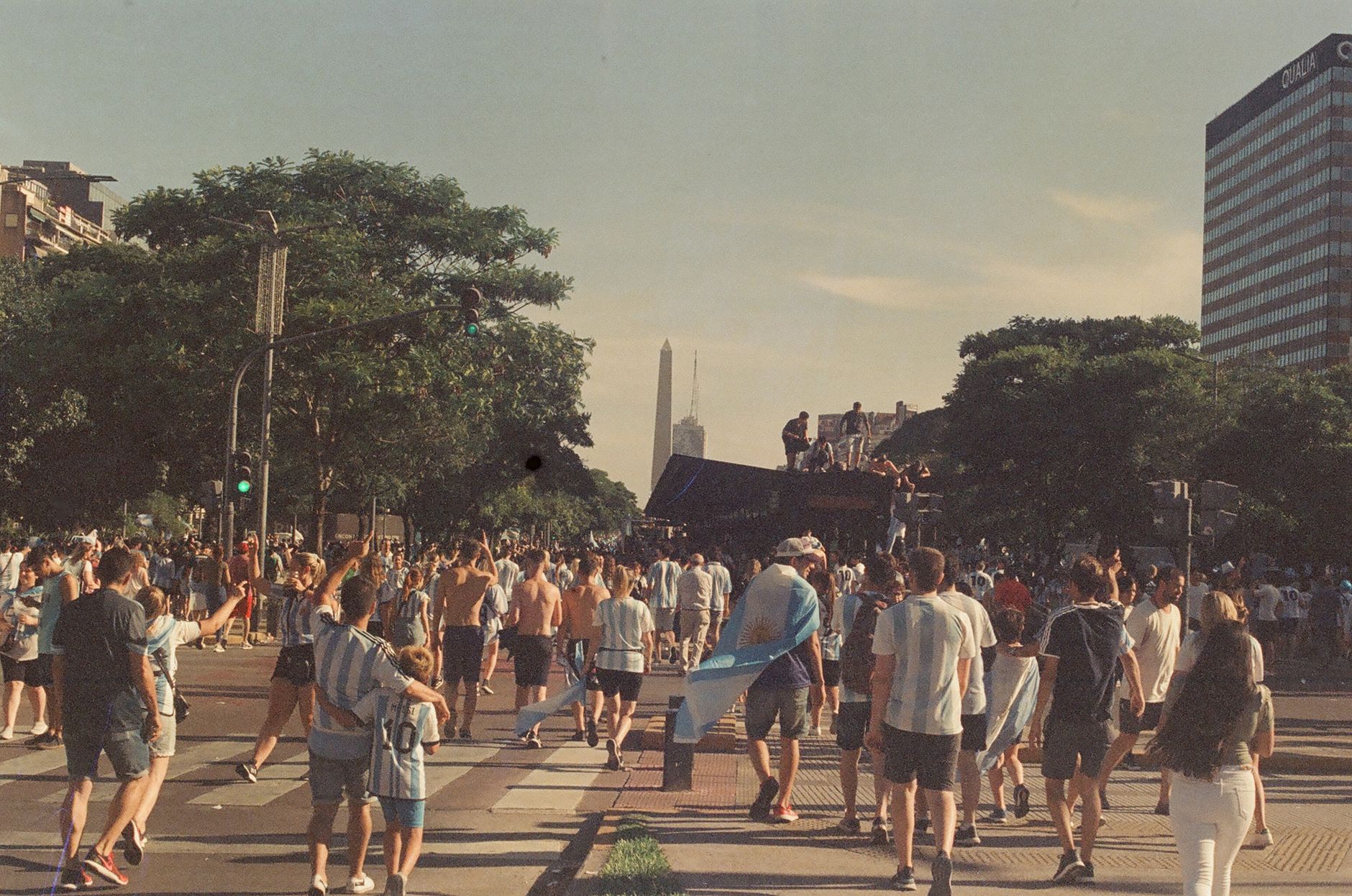 Argentinian football fans celebrate on a bustling street in Buenos Aires, embracing the World Cup victory.