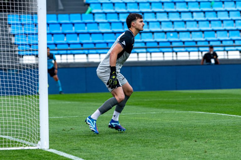 Goalkeeper in action during a soccer game, ready to defend the goal.