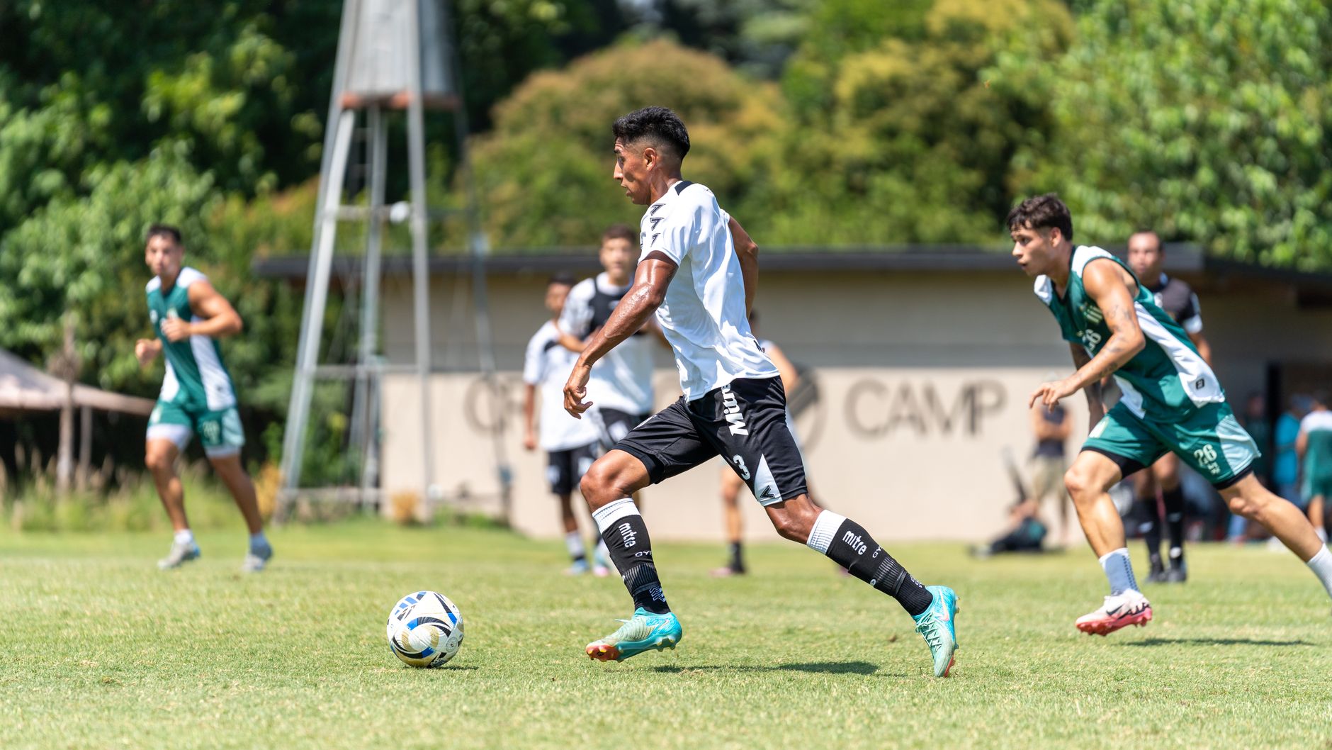 Players in action during a riveting soccer match on a sunny day outdoors, showcasing athletic skill and competition.