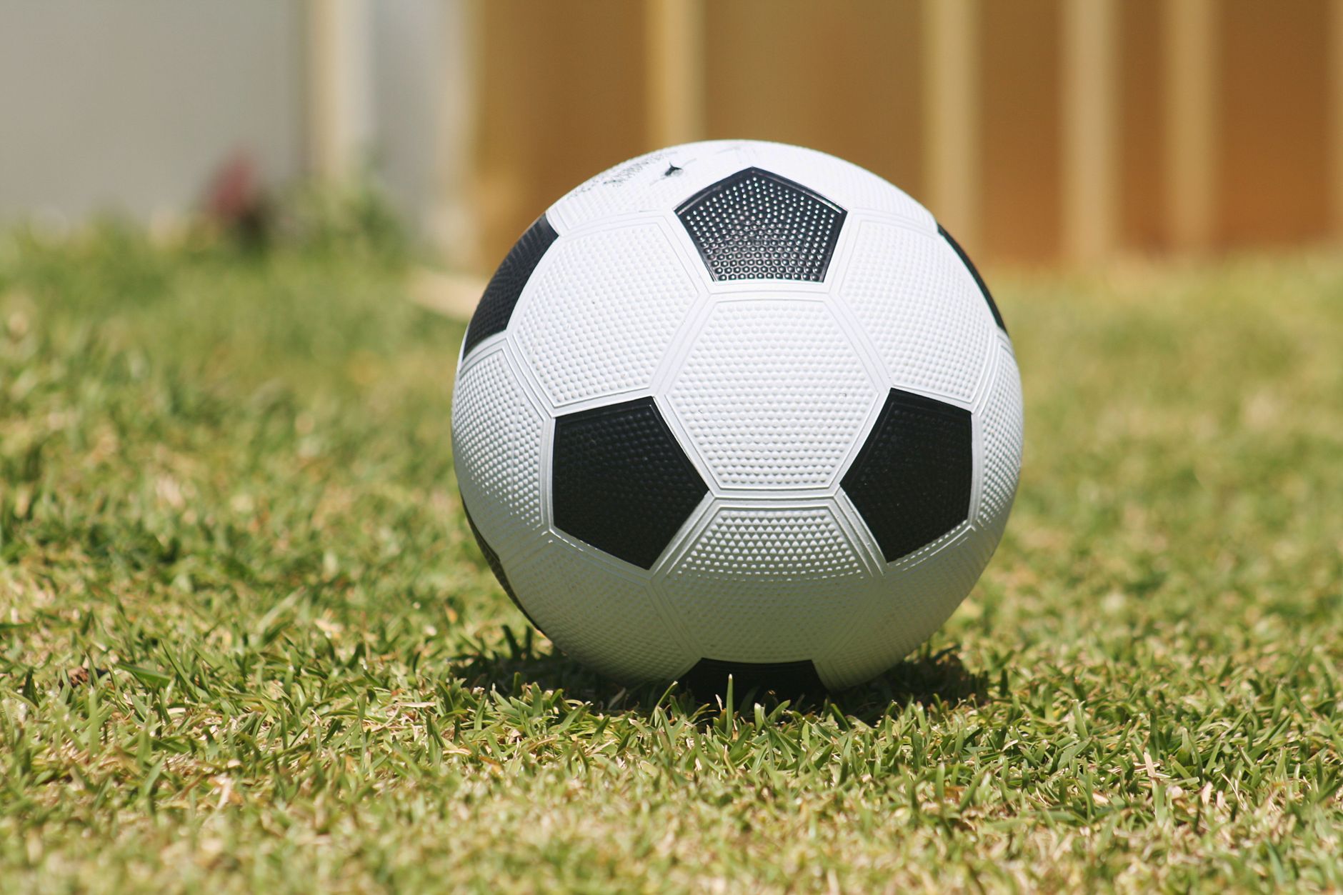 A close-up of a soccer ball resting on grass in Perth, showcasing outdoor sports.
