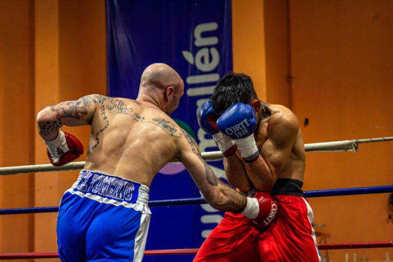 Two boxers in mid-action during a heated match, showcasing strength and skill.