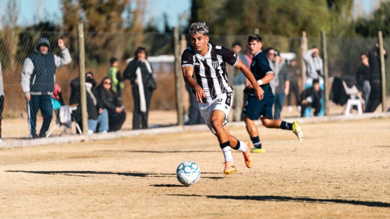 Soccer player in action during a match on a sunny day, showcasing teamwork and sportsmanship.