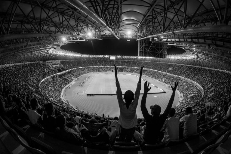 Black and white photo of a lively sports event at Kigali City Stadium, Rwanda.