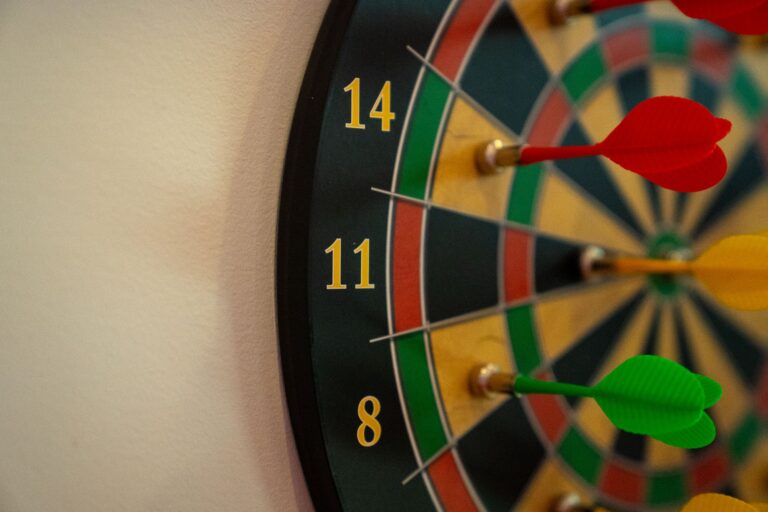 Vivid close-up of a dartboard with multicolored darts accurately striking the target.