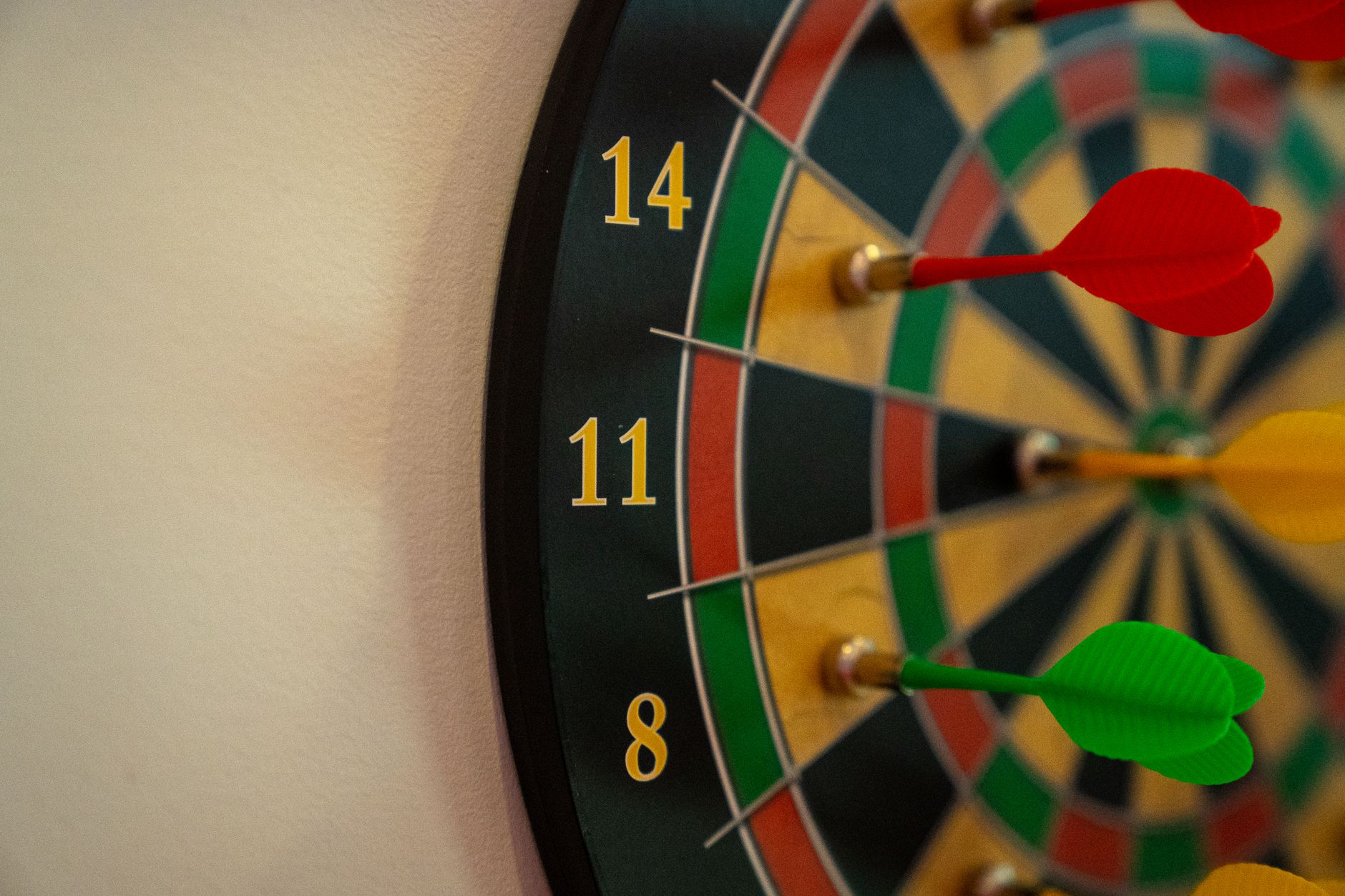 Vivid close-up of a dartboard with multicolored darts accurately striking the target.