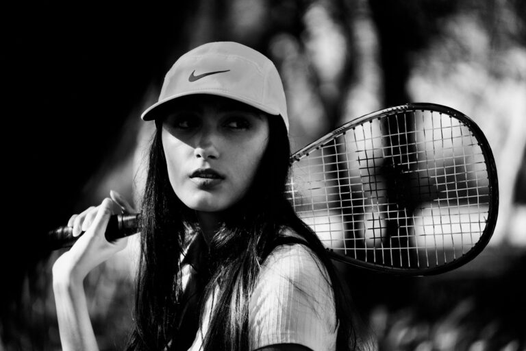 Striking black and white portrait of a female tennis player holding a racket reflect strength and elegance.